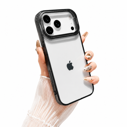 Hand with decorated nails holds a clear black-edged phone case upright against white. The phone logo shows through the plain transparent back below a broad camera frame.
