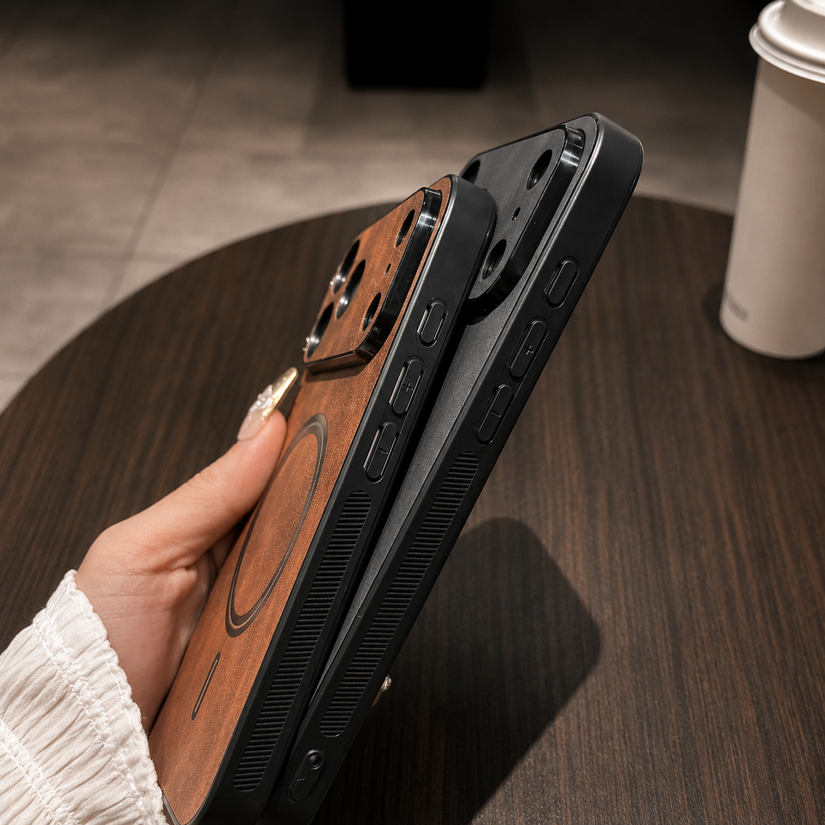 Angled side view of tan and charcoal cases held together, showing raised camera guards, covered side buttons and textured black edges.