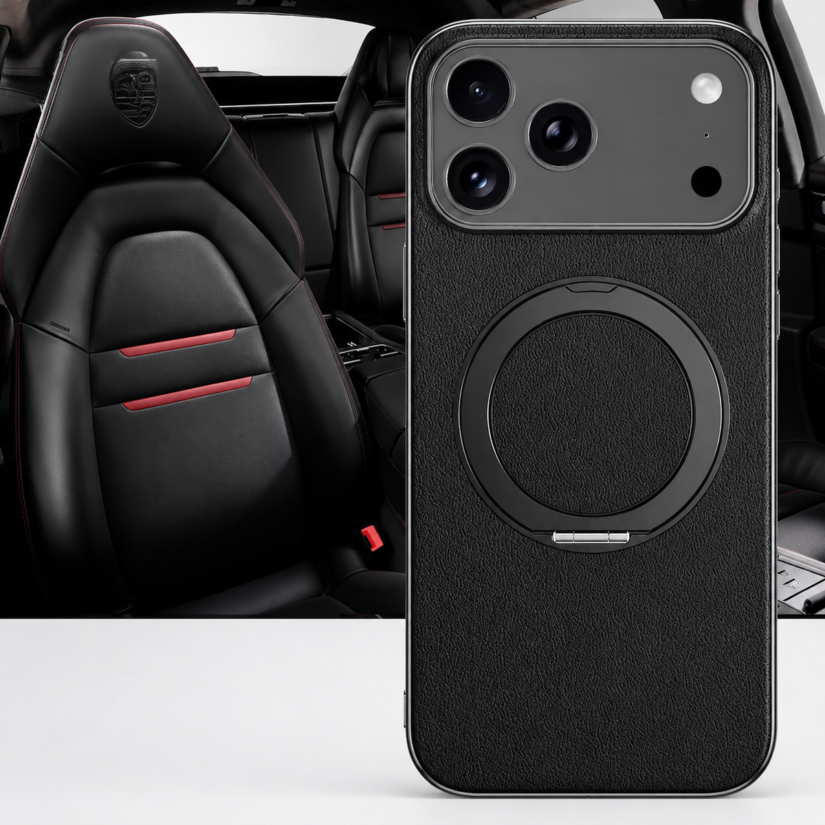 A black textured case stands in front of black sports-car seats, with a flat circular folding ring and silver-colored camera border facing forward.
