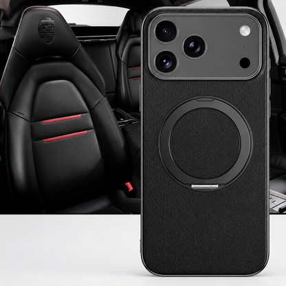 A black textured case stands in front of black sports-car seats, with a flat circular folding ring and silver-colored camera border facing forward.