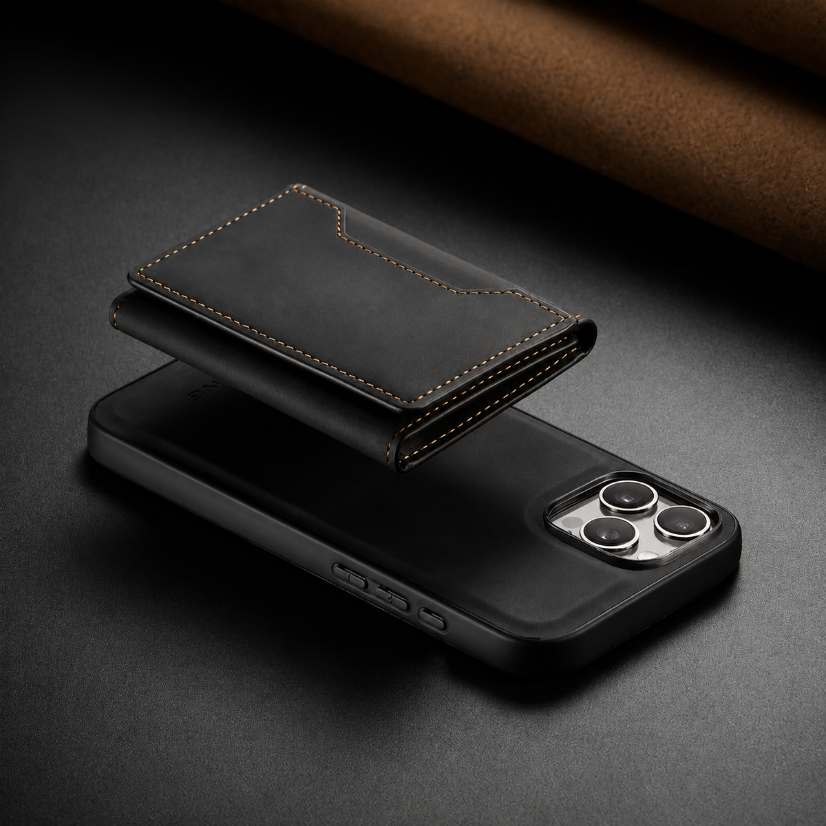Black stitched wallet floats above the back of a matching phone case on a dark tabletop, illustrating the detachable rear wallet.