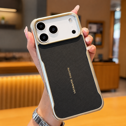 A hand holds a black textured phone case with reflective metallic edging and 'Ultimate Salute' lettering above a café counter.