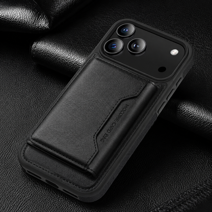 A black wallet case lies diagonally on textured black fabric, with a closed stitched flap below its broad camera panel.