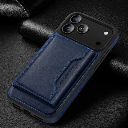 A navy wallet case lies diagonally on black textured fabric, showing its stitched rear flap and black camera panel.