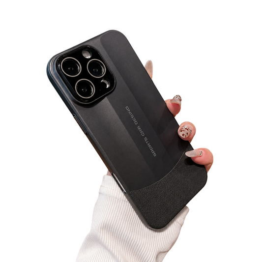 A hand in a white sleeve holds a dark gray phone case against white. An angular matte back panel contrasts with a textured darker lower section beneath a black camera panel.