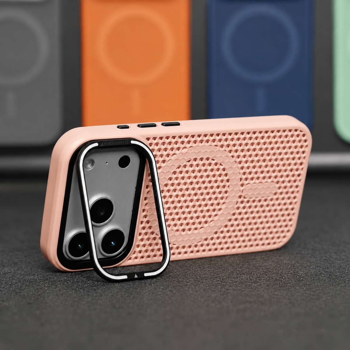 A pale pink perforated phone case stands horizontally on a silver-edged camera-frame stand, with a circular ring and short bar molded into its back.