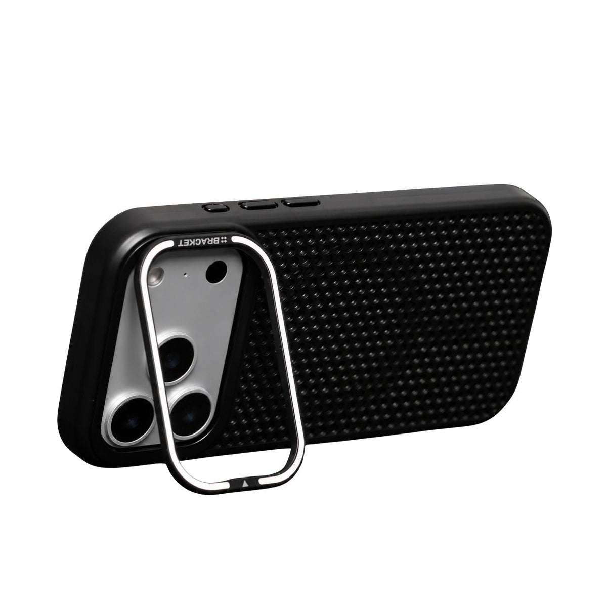 A black perforated phone case stands horizontally against white on a silver-edged rectangular stand hinged around its broad camera opening.