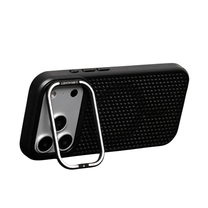 A black perforated phone case stands horizontally against white on a silver-edged rectangular stand hinged around its broad camera opening.