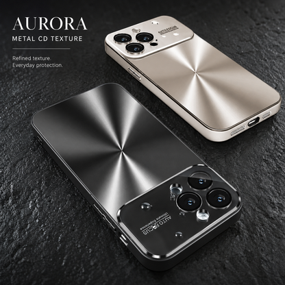 Champagne-colored and dark metallic-looking phone cases lie on rough black stone, showing radial brushed backs and reflective camera panels. Text labels the design “Aurora Metal CD Texture.”