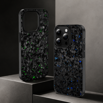 Green- and blue-flecked cases stand on stepped gray display blocks. One empty case shows its large camera opening; the other contains a phone with a dark camera panel.
