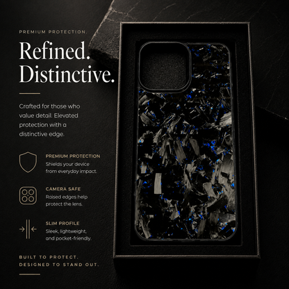 A black case with irregular gray fragments and blue flecks stands vertically inside a black tray, beside text promoting protection and raised camera edges.