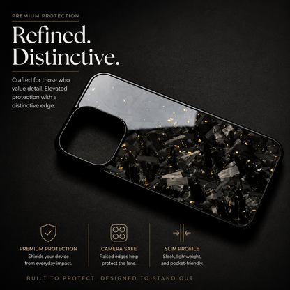 A glossy black case with gray fragments and gold flecks lies horizontally against black. The empty camera opening and raised rim are visible beside promotional protection text.