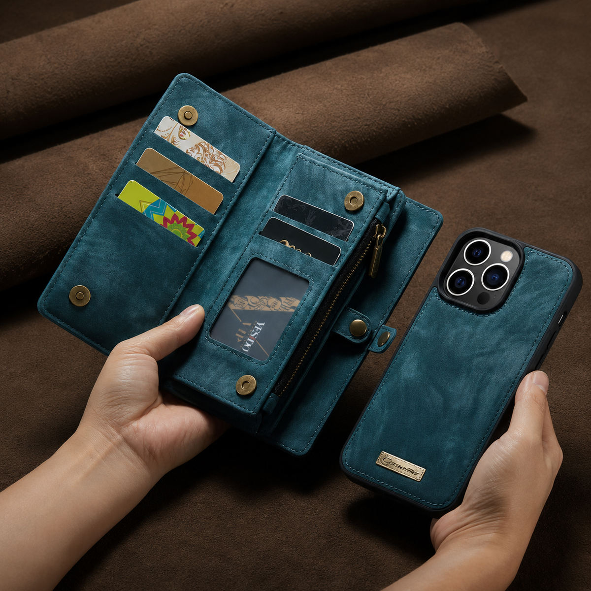 Two hands hold an open teal wallet organizer and its separate matching phone shell. Card slots, a clear window, zipper compartment and snap closure are visible.