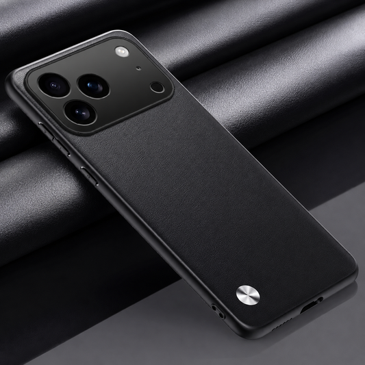 Black textured phone case lying diagonally on dark folded fabric, with a wide camera opening and small silver circular accent at the lower left.