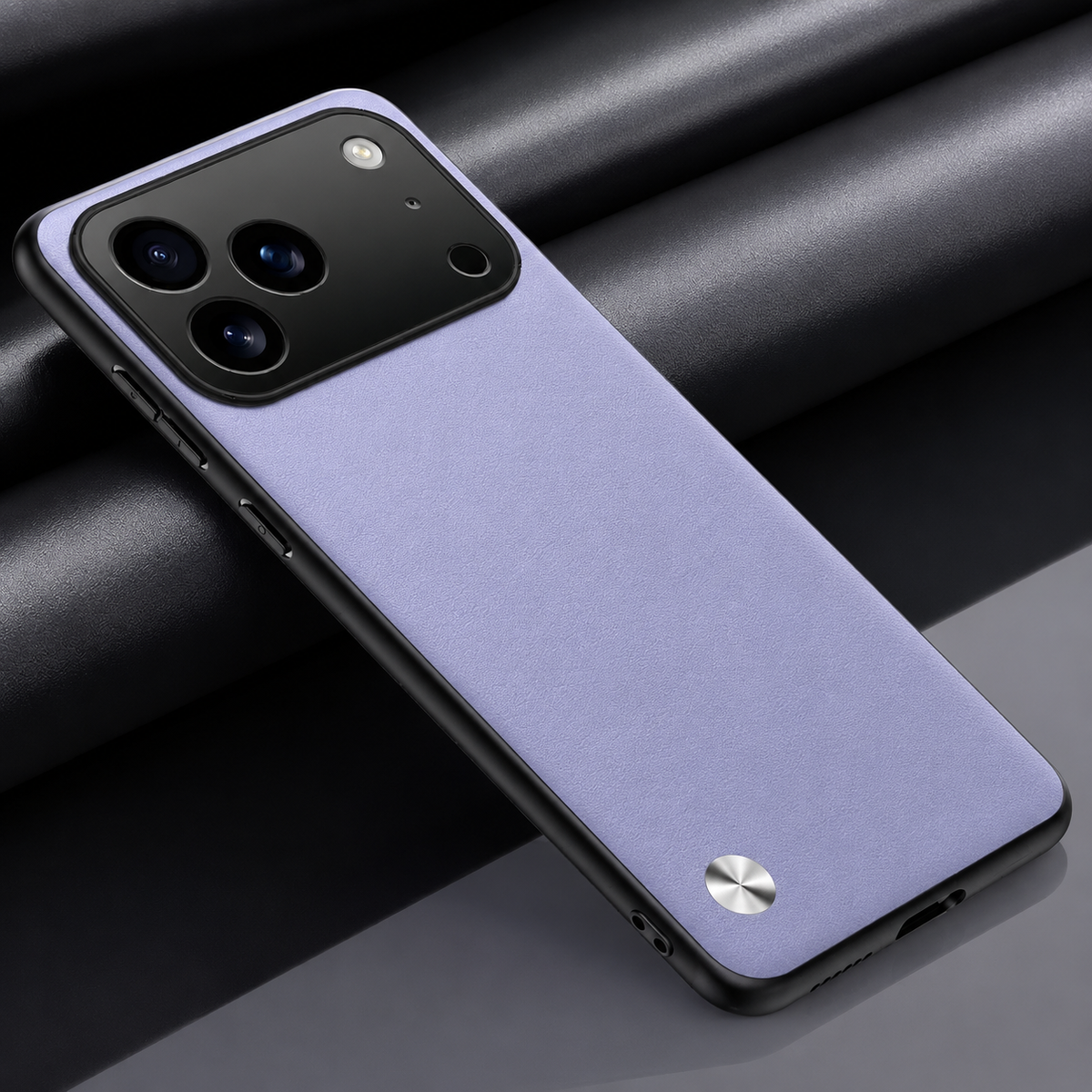 Lavender textured phone case on dark fabric, with black edging, a broad camera opening and a small silver circular accent near the bottom.