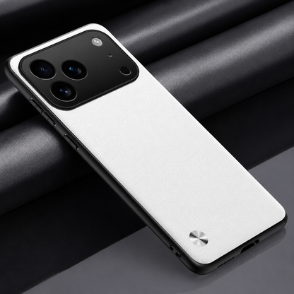 White textured phone case lying diagonally on dark fabric, with black edging, a broad camera opening and small silver circular accent.