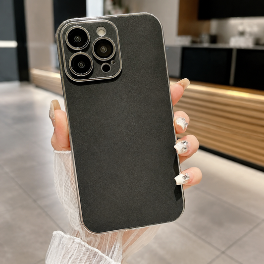 Hand holds a black suede-look case upright in a café, showing a finely mottled back, silver-colored border, and matching camera panel with individual lens openings.