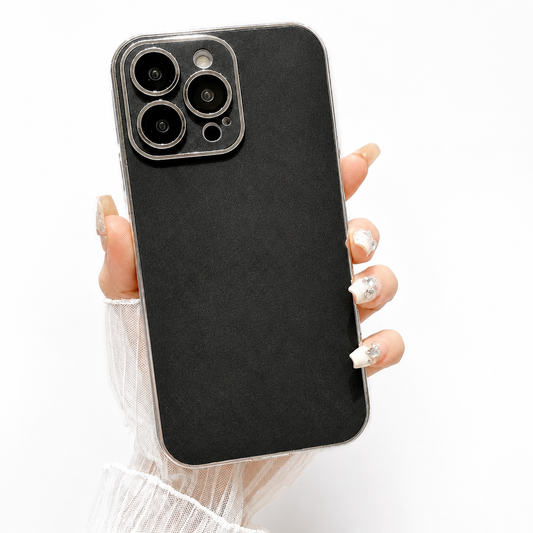 Hand holds a black suede-look case upright against white. A silver-colored edge surrounds its finely mottled back and matching camera panel with individually framed lens openings.