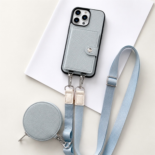 A pale blue textured wallet phone case rests on an angled white sheet beside a matching round zippered pouch and long adjustable strap. A stitched card flap with a silver-colored snap covers the rear. Metal clips connect the strap to two loops on the phone's lower edge, with pale fabric sections near the clips.