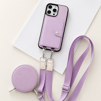 A lavender textured wallet phone case rests on an angled white sheet beside a matching round zippered pouch and long adjustable strap. A stitched card flap with a silver-colored snap covers the rear. Metal clips connect the strap to two loops on the phone's lower edge, with pale fabric sections near the clips.