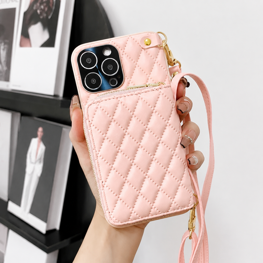 A hand holds a pale pink diamond-quilted phone wallet in front of framed fashion pictures. A zippered pouch covers the lower back, with gold-colored fittings and a matching strap.