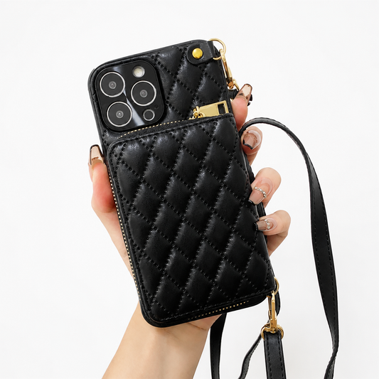 A hand holds a black diamond-quilted phone wallet against white. A zippered pouch covers the lower back, with gold-colored fittings and a long matching strap clipped at opposite corners.