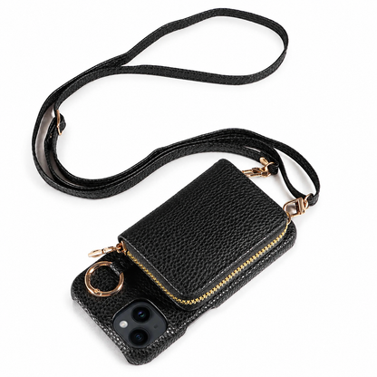 A black pebbled leather-look phone case lies on white with a matching long strap looped above it. A gold-colored zipper surrounds a rectangular wallet pouch on the back, beside a circular ring.