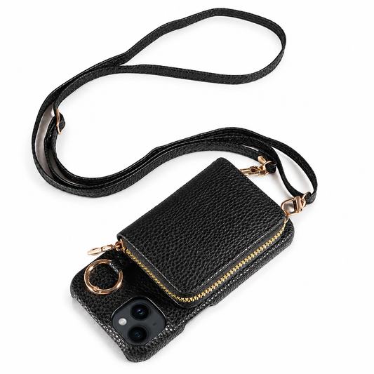 A black pebbled leather-look phone case lies on white with a matching long strap looped above it. A gold-colored zipper surrounds a rectangular wallet pouch on the back, beside a circular ring.