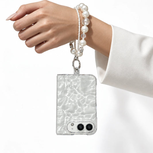 Image of iphone duo clear 3d water ripple phone case, showing pearl phone bracelet in studio light.